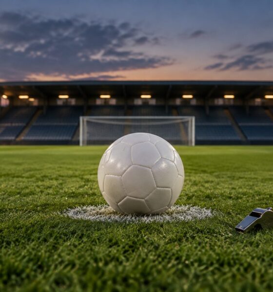 Fotboll på straffpunkten på en upplyst arena, med en domarvissla bredvid